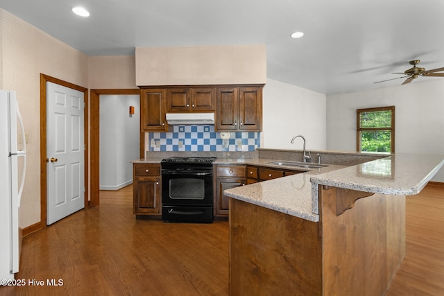 163 Middleton Dr, Hertford, NC 27944 - kitchen with a sink, under cabinet range hood, black electric range oven, a peninsula, and freestanding refrigerator