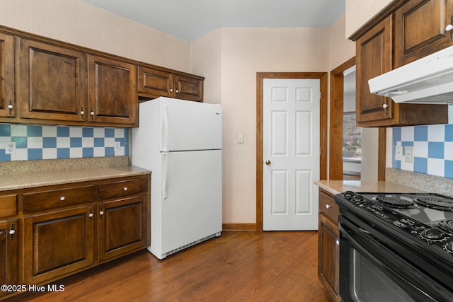 163 Middleton Dr, Hertford, NC 27944 - kitchen with dark wood-style floors, under cabinet range hood, light countertops, black electric range, and freestanding refrigerator
