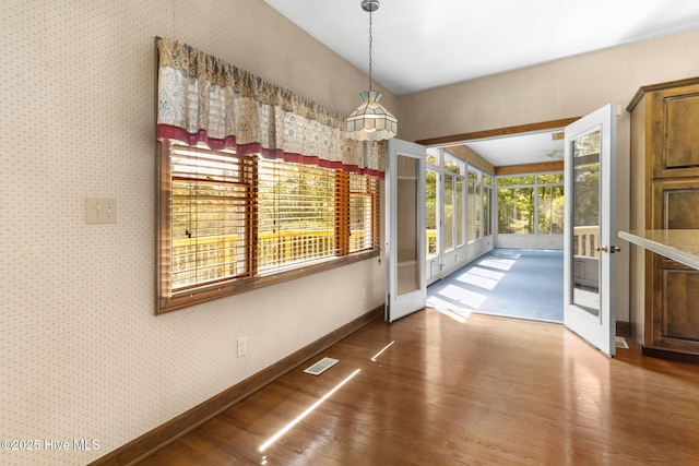 163 Middleton Dr, Hertford, NC 27944 - unfurnished dining area with visible vents, french doors, wallpapered walls, baseboards, and wood finished floors