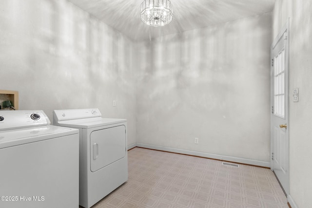 163 Middleton Dr, Hertford, NC 27944 - clothes washing area with washer and clothes dryer, a notable chandelier, laundry area, baseboards, and light floors