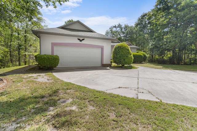 163 Middleton Dr, Hertford, NC 27944 - exterior space featuring stucco siding, a shingled roof, a garage, driveway, and a lawn