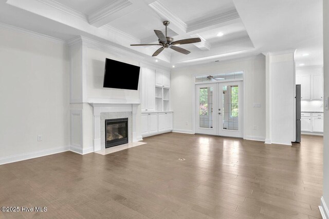 661 Jenoa Loop, Castle Hayne, NC 28429 - unfurnished living room featuring a ceiling fan, crown molding, french doors, a tiled fireplace, and beam ceiling