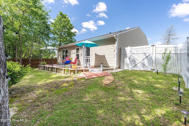 1516 Round Ridge Rd SE, Bolivia, NC 28422 - rear view of property featuring a fenced backyard, a gate, a wooden deck, and a lawn