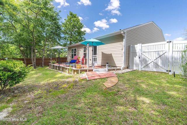 1516 Round Ridge Rd SE, Bolivia, NC 28422 - back of house featuring a lawn, a gate, fence, and a deck