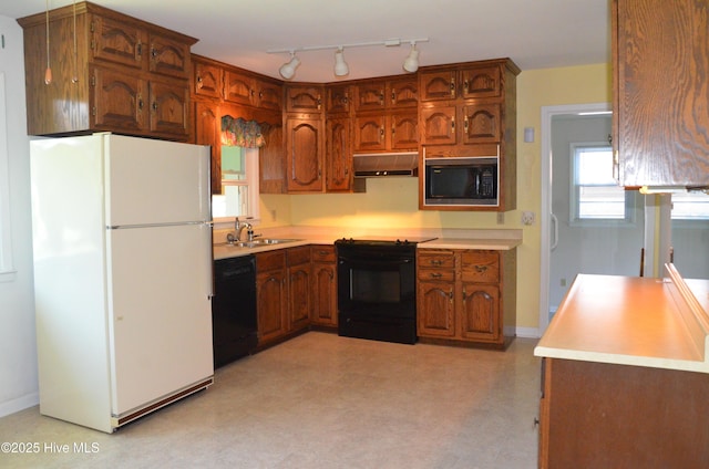 101 N Channel Haven Dr, Wilmington, NC 28409 - kitchen featuring black appliances, under cabinet range hood, light countertops, a sink, and light flooring