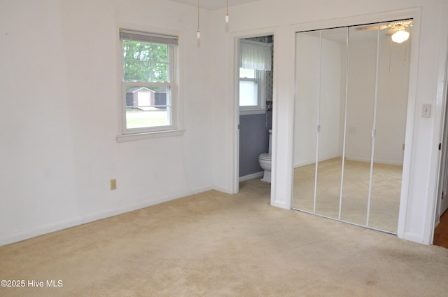101 N Channel Haven Dr, Wilmington, NC 28409 - unfurnished bedroom featuring multiple windows, carpet, a closet, and ensuite bathroom