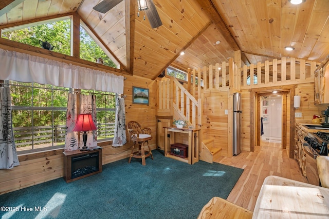 280 Charlie Rd, Arapahoe, NC 28510 - living room featuring wooden walls, stairs, high vaulted ceiling, a ceiling fan, and wood finished floors