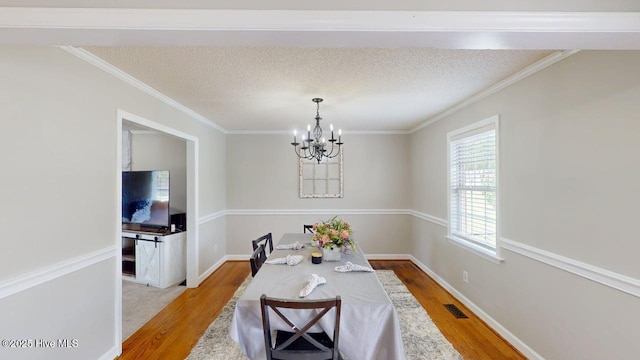 106 Ehrhardt Way, Princeton, NC 27569 - dining room featuring visible vents, crown molding, wood finished floors, baseboards, and a chandelier