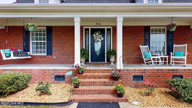 106 Ehrhardt Way, Princeton, NC 27569 - entrance to property featuring covered porch, a shingled roof, crawl space, and brick siding