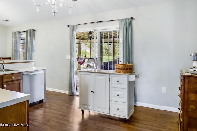kitchen featuring a sink, dark wood-style floors, dishwasher, and plenty of natural light