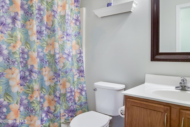 bathroom with a shower with shower curtain, toilet, and vanity
