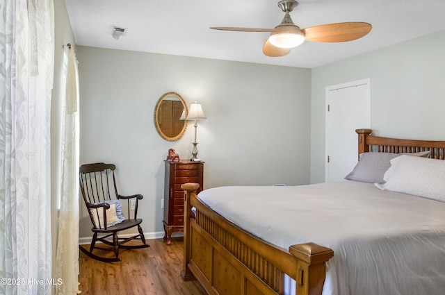 bedroom with a ceiling fan, baseboards, and light wood-style floors