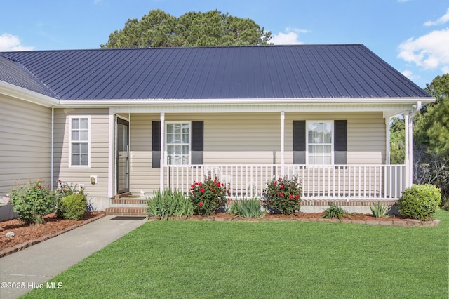 view of front of home with covered porch, metal roof, and a front lawn