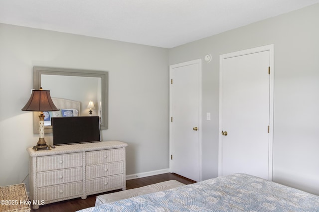 bedroom with dark wood-style floors and baseboards