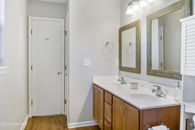 full bathroom with wood finished floors, baseboards, and a sink