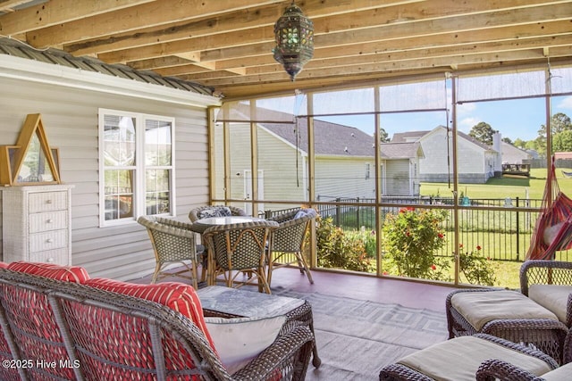 sunroom with a residential view and outdoor dining area