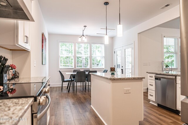 102 Dartmoor Ln, West End, NC 27376 - kitchen with white cabinetry, appliances with stainless steel finishes, wall chimney range hood, and dark wood finished floors