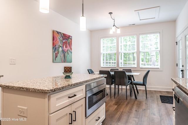 102 Dartmoor Ln, West End, NC 27376 - kitchen featuring light stone counters, wood finished floors, dishwasher, and hanging light fixtures