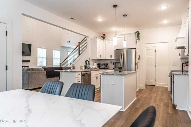 102 Dartmoor Ln, West End, NC 27376 - kitchen featuring stainless steel appliances, visible vents, a kitchen island, open floor plan, and dark wood finished floors