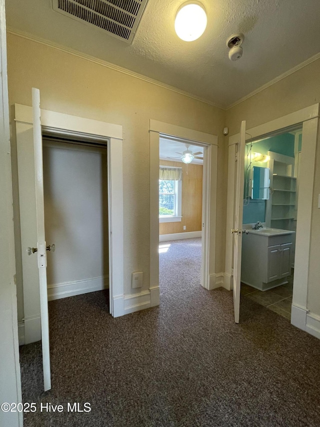 469 Lamont St, Belhaven, NC 27810 - hallway with carpet floors, a textured ceiling, crown molding, and visible vents