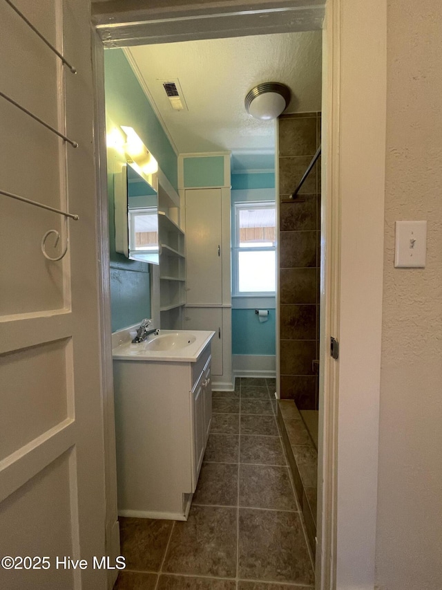 469 Lamont St, Belhaven, NC 27810 - bathroom with tile patterned floors, visible vents, walk in shower, crown molding, and vanity