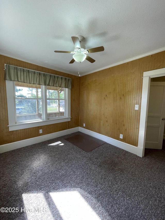 469 Lamont St, Belhaven, NC 27810 - carpeted empty room with ornamental molding, baseboards, ceiling fan, and wood walls