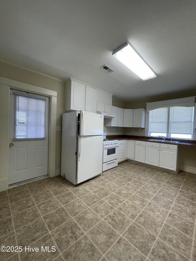 469 Lamont St, Belhaven, NC 27810 - kitchen featuring white cabinets, a sink, a textured ceiling, dark countertops, and white appliances