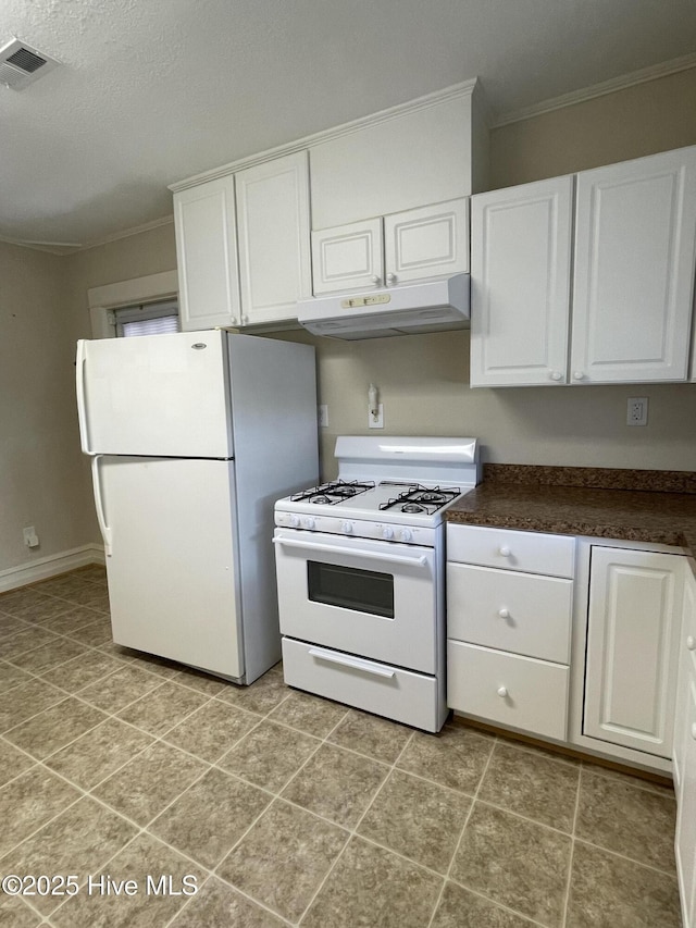 469 Lamont St, Belhaven, NC 27810 - kitchen with under cabinet range hood, dark countertops, white appliances, crown molding, and white cabinetry