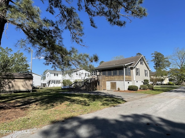 469 Lamont St, Belhaven, NC 27810 - view of front of property with driveway, a shingled roof, stairway, a sunroom, and a front yard