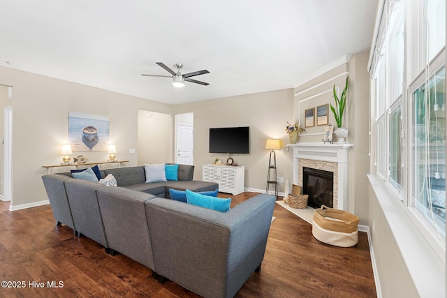 1699 Haldon Ln SE, Bolivia, NC 28422 - living area featuring dark wood-style flooring, a ceiling fan, baseboards, and a stone fireplace
