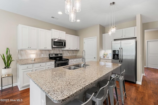1699 Haldon Ln SE, Bolivia, NC 28422 - kitchen with appliances with stainless steel finishes, tasteful backsplash, a sink, dark wood-style floors, and white cabinetry
