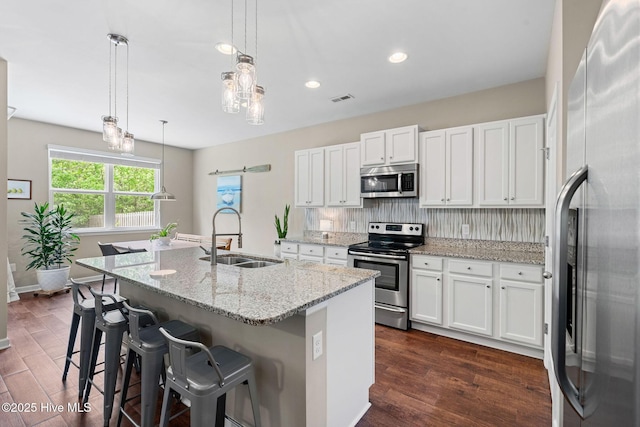 1699 Haldon Ln SE, Bolivia, NC 28422 - kitchen featuring appliances with stainless steel finishes, a sink, an island with sink, backsplash, and visible vents