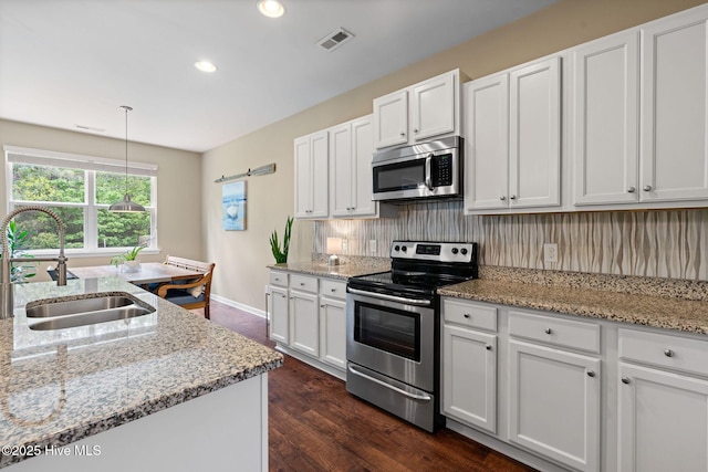 1699 Haldon Ln SE, Bolivia, NC 28422 - kitchen with dark wood-type flooring, a sink, white cabinets, and stainless steel appliances