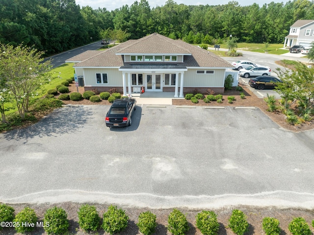 1699 Haldon Ln SE, Bolivia, NC 28422 - view of front of house featuring uncovered parking, a forest view, french doors, and a shingled roof