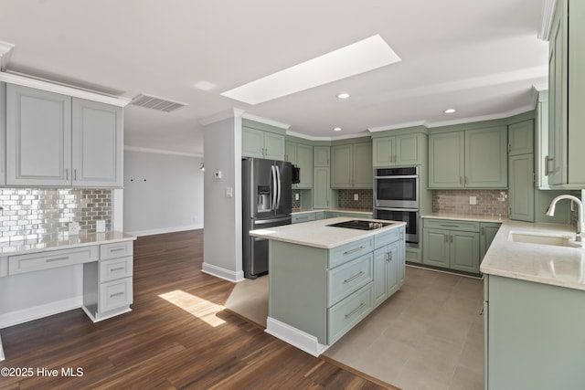 995 Chadwick Shores Dr, Sneads Ferry, NC 28460 - kitchen featuring appliances with stainless steel finishes, a sink, green cabinets, a skylight, and recessed lighting