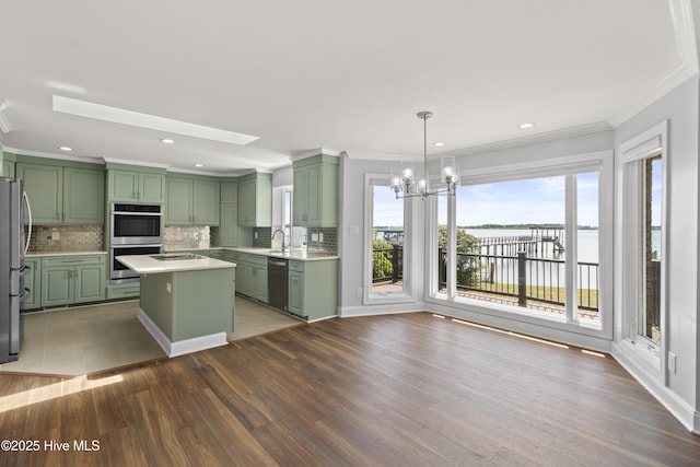 995 Chadwick Shores Dr, Sneads Ferry, NC 28460 - kitchen featuring green cabinetry, stainless steel appliances, light countertops, crown molding, and a chandelier
