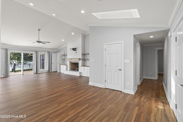 995 Chadwick Shores Dr, Sneads Ferry, NC 28460 - unfurnished living room with a skylight, a brick fireplace, dark wood-style flooring, ornamental molding, and ceiling fan