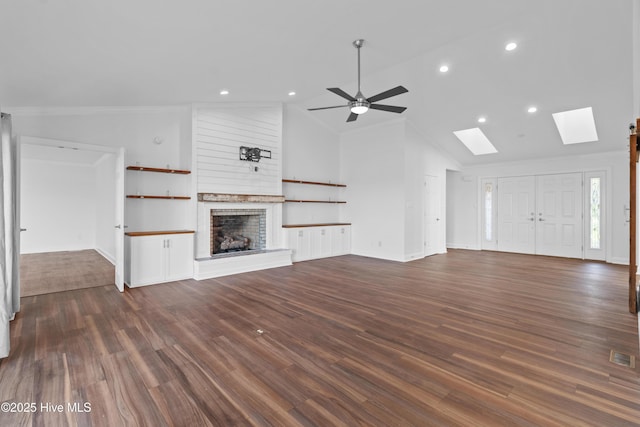 995 Chadwick Shores Dr, Sneads Ferry, NC 28460 - unfurnished living room with a skylight, a brick fireplace, dark wood-style floors, lofted ceiling, and a ceiling fan