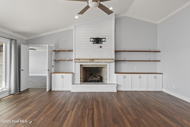 995 Chadwick Shores Dr, Sneads Ferry, NC 28460 - unfurnished living room featuring lofted ceiling, ceiling fan, dark wood-style floors, a brick fireplace, and baseboards