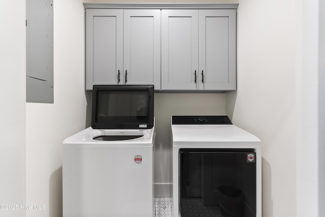 clothes washing area with washer and dryer, tile patterned flooring, and cabinet space