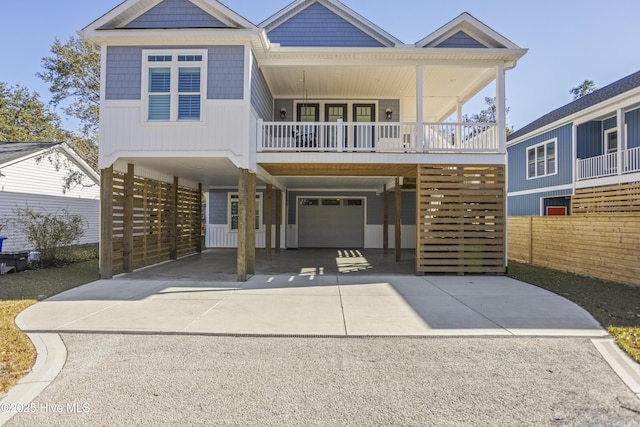 view of front facade with covered porch, a garage, driveway, and a carport