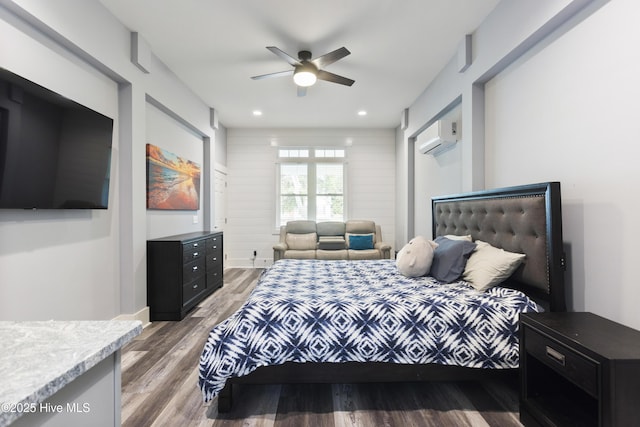 bedroom featuring ceiling fan, a wall unit AC, recessed lighting, and wood finished floors