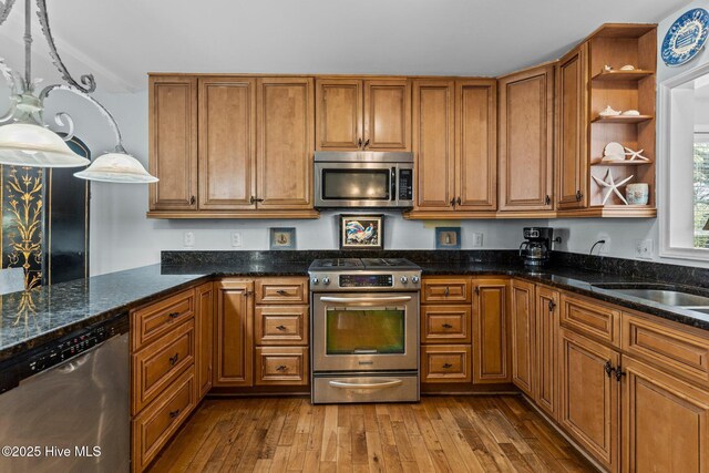 1613 E Pelican Dr, Oak Island, NC 28465 - kitchen featuring open shelves, dark wood finished floors, brown cabinetry, and appliances with stainless steel finishes