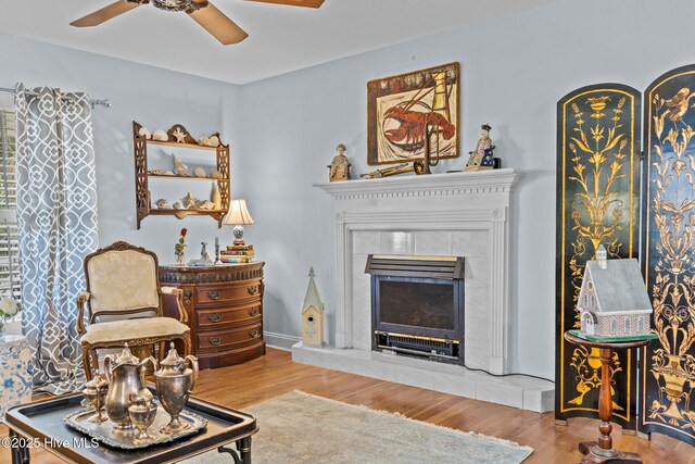 1613 E Pelican Dr, Oak Island, NC 28465 - living area featuring a tiled fireplace, wood finished floors, and ceiling fan