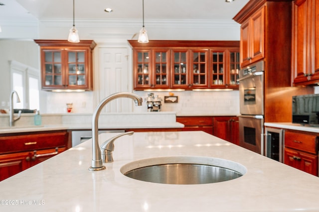 kitchen featuring a sink, pendant lighting, stainless steel double oven, and wine cooler