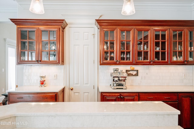kitchen with glass insert cabinets, crown molding, tasteful backsplash, and reddish brown cabinets
