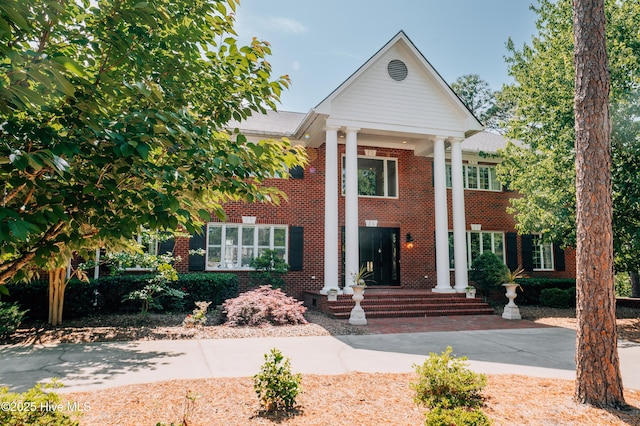 greek revival inspired property featuring brick siding