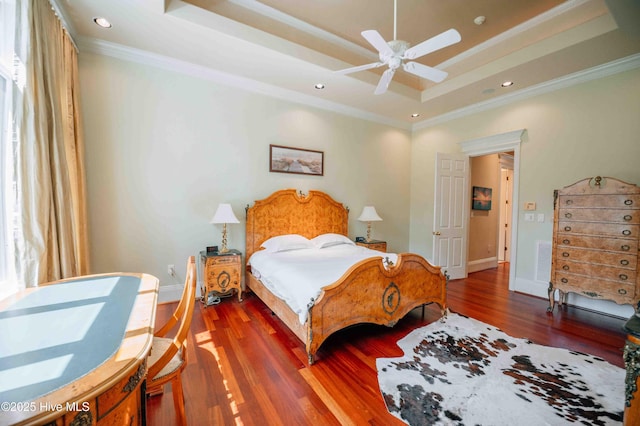 bedroom featuring crown molding, a raised ceiling, and wood finished floors