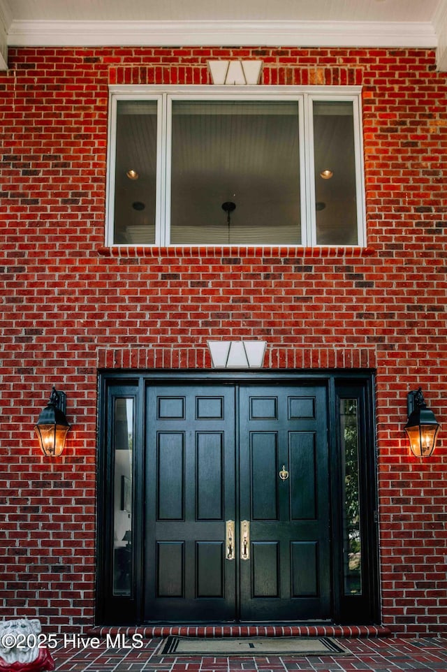 view of exterior entry with brick siding