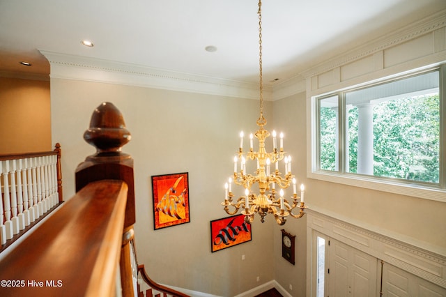 foyer with crown molding and a chandelier